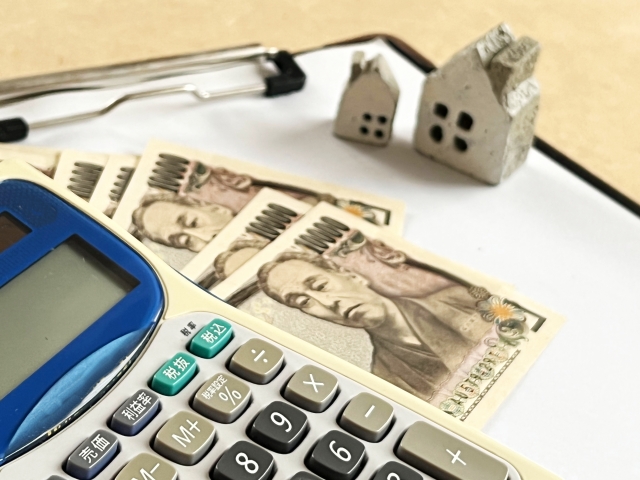 家と電卓とお金がセットでおいてあるイメージ画像。