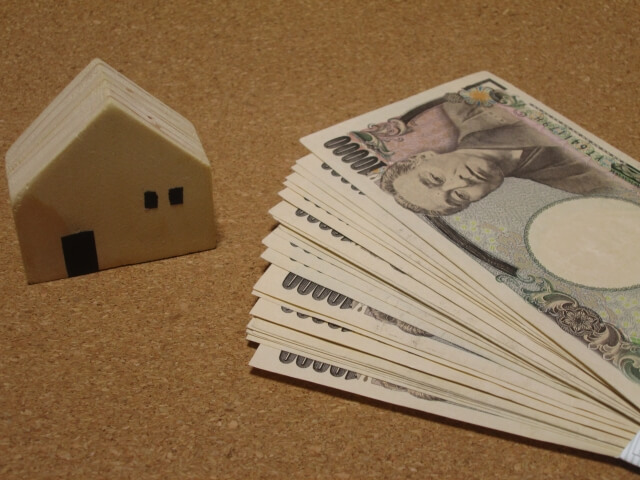 空き家とお金が並んでいるイメージ画像。